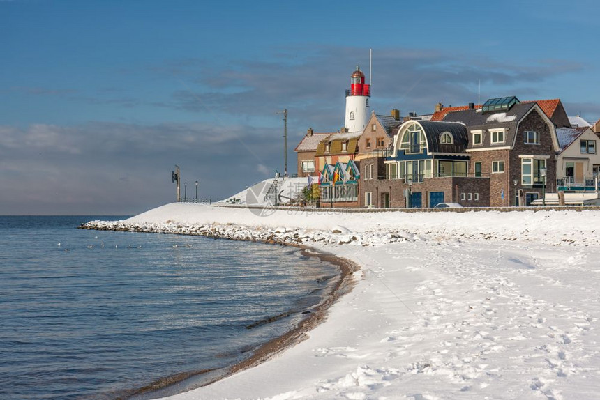 冬季风景荷兰海滩覆盖着雪和鱼村乌尔克的灯塔风景荷兰海滩覆盖着雪和灯塔乌尔克风景图片