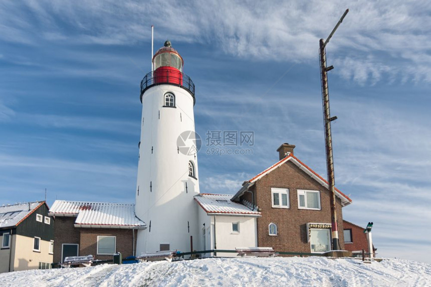 荷兰冬季乌尔克渔村的灯塔有雪和风景图片