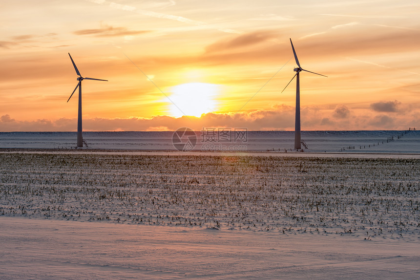 风力涡轮机和农田覆盖着积雪风力涡轮机和覆盖着荷兰冬季风景图片
