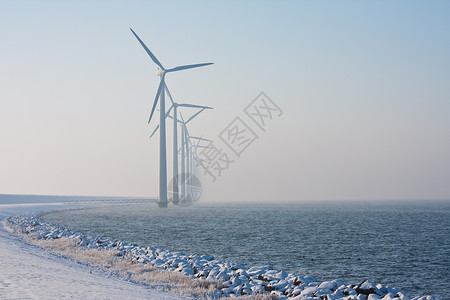 荷兰长排风车在冬季烟雾中消失高清图片