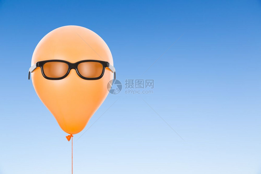 橙色气球与太阳镜对着蓝色天空和复制间图片