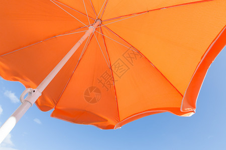 橙色阳伞与蓝天的颜色多彩底部视图背景图片