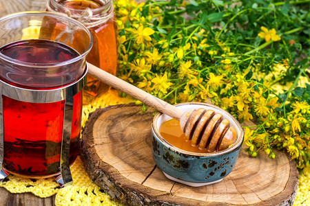 黄色蜂蜜液体草药茶蜂蜜和新鲜药用植物放在石板上工作室照片草药茶蜂蜜和新鲜药用植物放在石板上背景