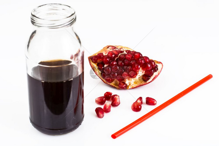 在玻璃瓶中甜美的成熟石榴和果汁工作室照片甜美的成熟石榴和果汁在玻璃瓶中图片