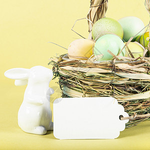 黄色背景的复活节鸡蛋和小白兔图片