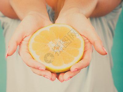 女手上一半的黄葡萄果柑橘水健康饮食体重减值概念背景图片