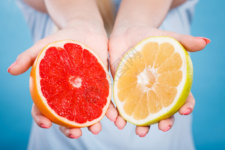 女手掌中的黄果和红葡萄柑橘水果一半女口腔卫生员建议健康饮食营养人手中的黄红葡萄柑橘水果一半背景图片