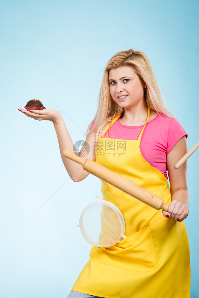 在家烘焙美味的甜点和糖果的概念女人拿着美味的巧克力蛋糕擀面杖和香炉围着围裙拿着纸杯蛋糕擀面杖穿着围裙的滤壶的女人图片