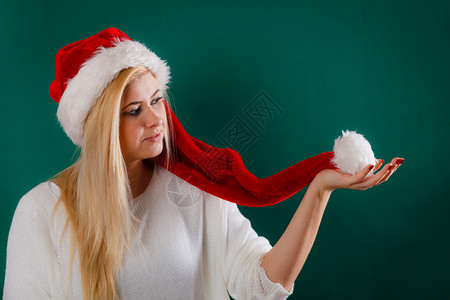 戴圣诞老人红帽子的妇女等待圣诞礼物和节假日与蓬玩耍图片