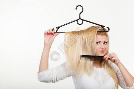 美发型和销售概念金发女人在衣架上抓头发金女人在衣架上抓头发图片