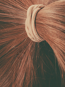 棕色黑金头发和马尾的辫头发表面棕色马尾辫的头发背景图片