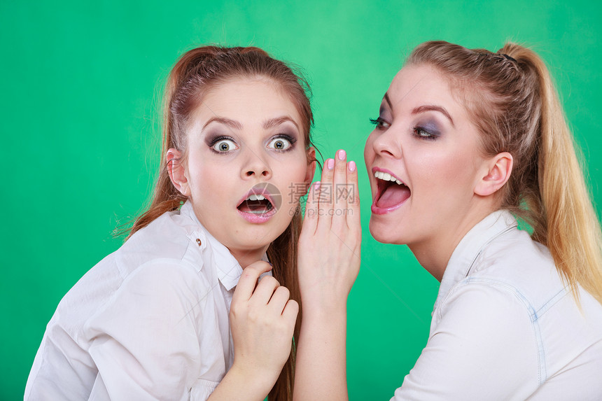 年轻女人告诉朋友一些秘密两个女人在说八卦图片