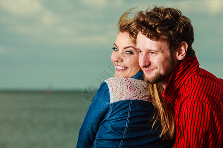 爱夫妻在海岸拥抱的侧观滩上共度闲暇时间图片