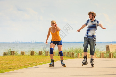 在户外玩轮滑鞋的年轻情侣背景图片