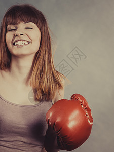 穿着红拳击手套打斗的体育女运动员工作室在灰色背景上拍摄背景图片