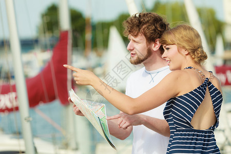 暑期旅行概念度假的年轻旅游夫妇站在船坞的前上寻找方向图片