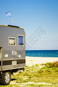 在海滩上扎营卡车屋顶上悬挂希腊旅行冒险概念有希腊的野营卡车图片