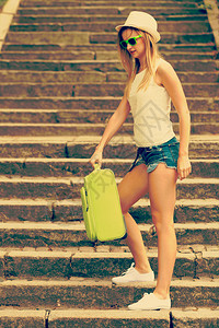 女旅行者手提绿色行李箱图片