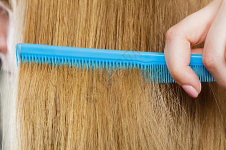 结合和梳洗概念日常卫生闭紧金发的蓝梳子图片
