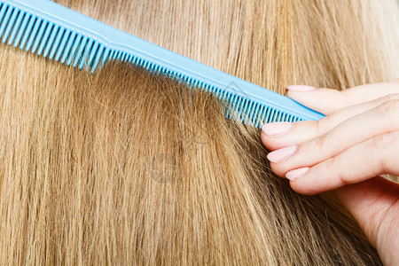 结合和梳洗概念日常卫生闭紧金发的蓝梳子图片