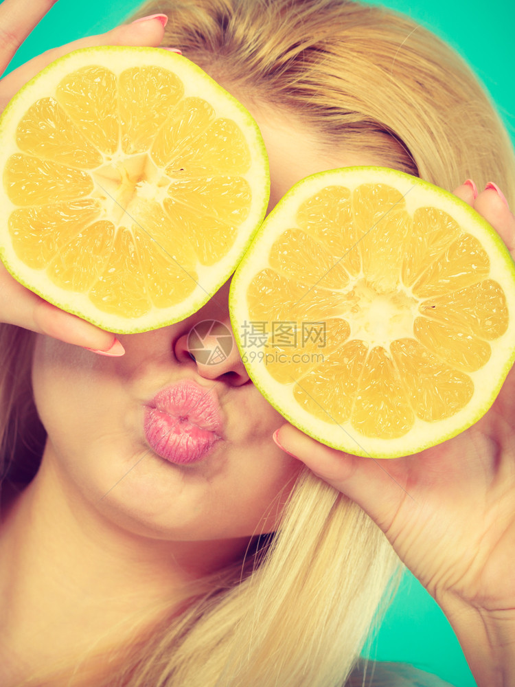 金发女少手拿着两半黄葡萄果柑橘水蒙上眼睛涂蓝色绿健康饮食营养幸福快乐概念女孩用葡萄汁蒙上眼睛图片