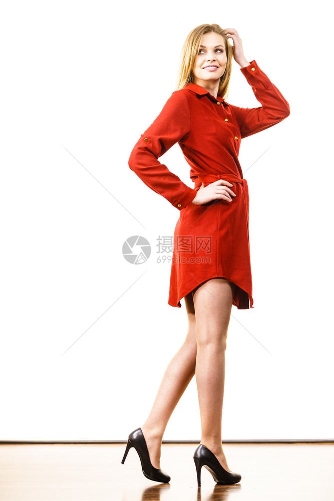 穿着优雅的红短裙和黑色时装高跟鞋的超级时装女郎图片