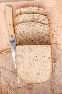 食品切碎整片小麦面包和刀背景图片