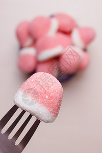 甜食粉糖加手握叉子伸出从碗里取糖果背景图片