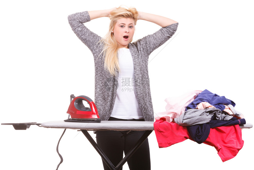 干家务照顾庭概念疲劳的打哈女人站在板后用一堆衣服熨铁疲劳的打哈同时熨铁疲劳的打图片