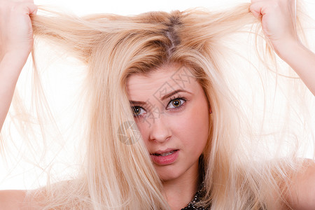 头发护理错误漂白问题的概念金发女人抱着她干枯受损的头发拿着干头发的金发女人背景图片