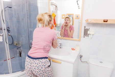 敏感干皮肤问题的概念害怕的女人在水槽下洗脸害怕的女人在水槽下洗脸图片