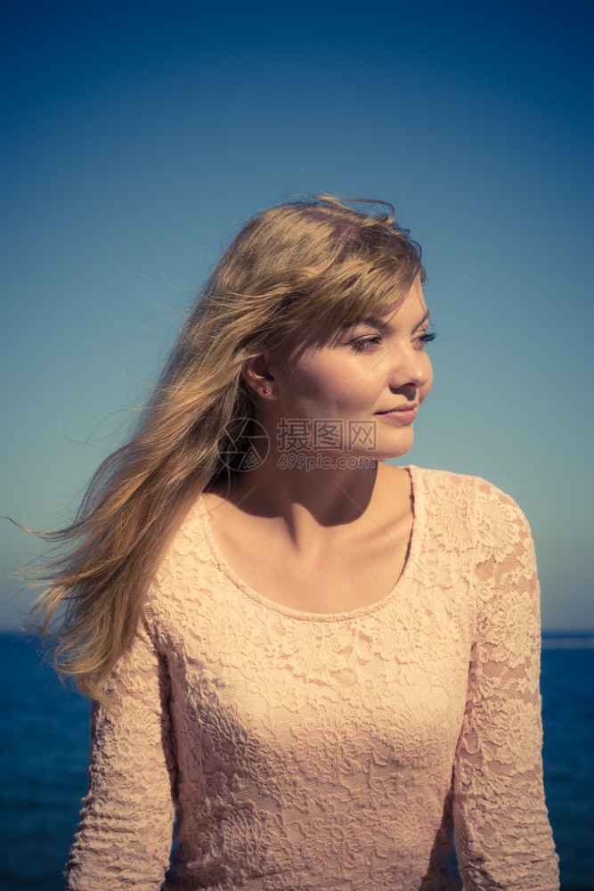 美丽的金发女孩在海边户外放松图片