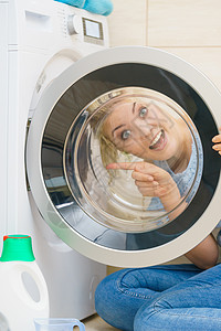 洗衣机内筒女人在洗衣机门内看调查洗涤浴室内液女人在洗衣机内看背景