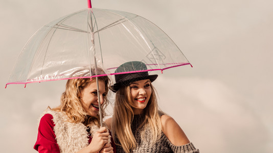 两名穿着时尚服装的妇女穿着服装拥有透明的伞式服装在户外自由度日图片