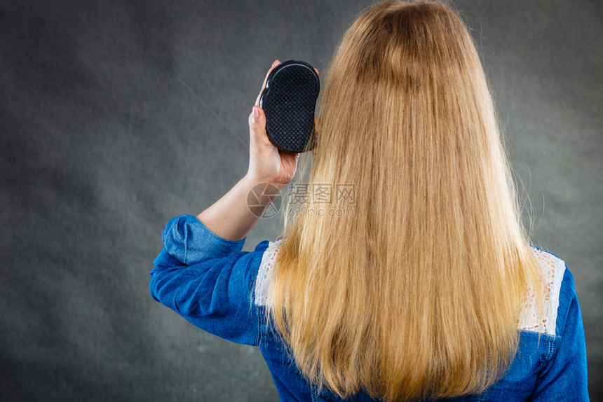 每天卫生关心美貌金发女的背影梳她长头发女人用黑梳子头发金女人梳她的头图片