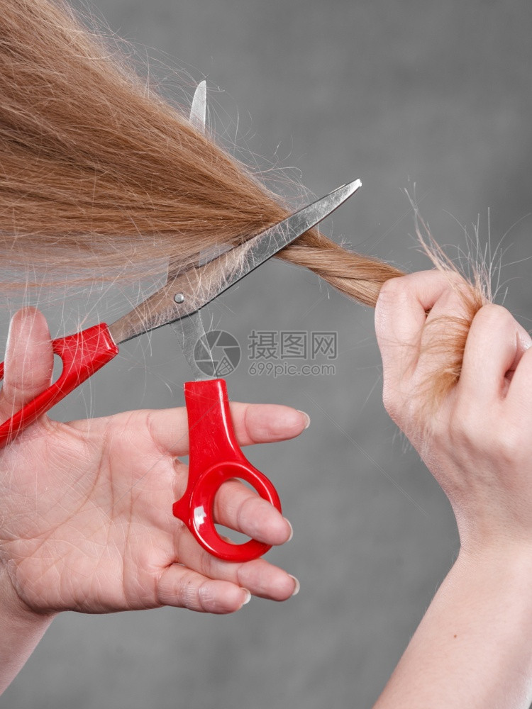 一身金发女人剪了长的直发一手红色剪刀制造现代发型一双金女人剪了头图片