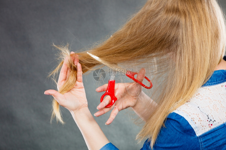 一身金发女人剪了长的直发一手红色剪刀制造现代发型一双金女人剪了头图片