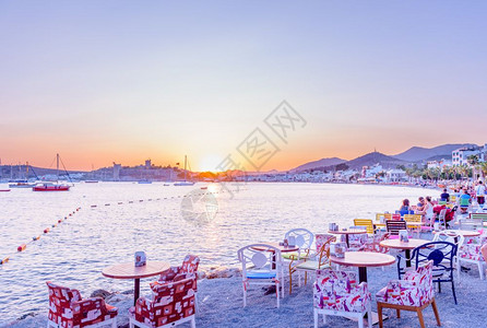 2017年8月3日土耳其博德鲁姆海滩咖啡馆和博德鲁姆海洋日落风景中有游艇和圣彼得城堡或博德鲁姆风景中有身份不明的人享受背景