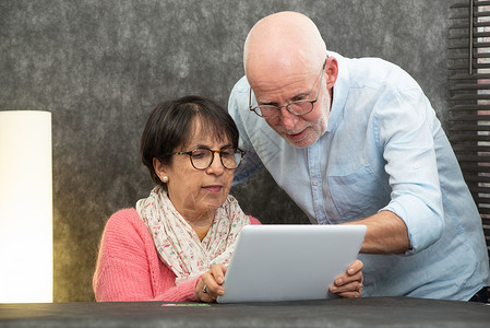 使用平板电脑的幸福老年情侣图片
