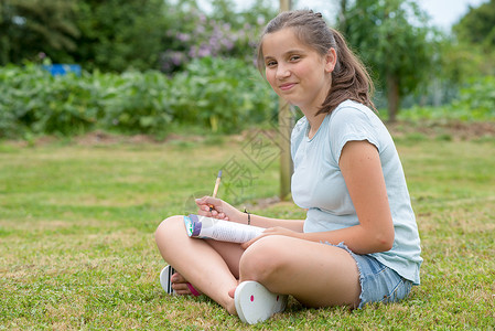 一位坐在草地上横行写字的年轻少图片