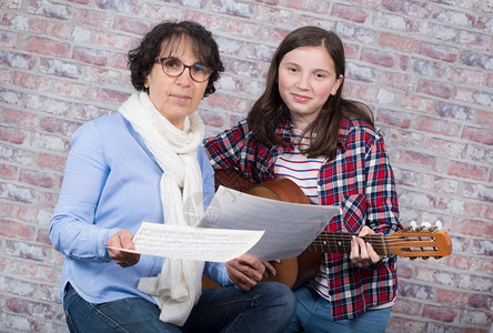 一个年轻的少女与老师一起学习弹吉他爱好高清图片素材