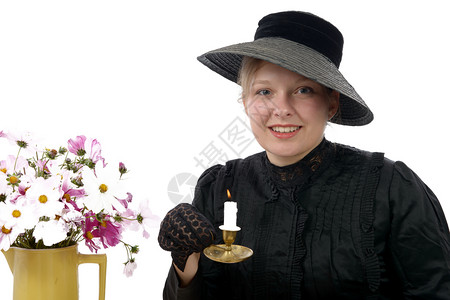 一位年轻女子穿着190年代的旧装和蜡烛图片