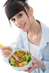 美丽的年轻黑发女吃沙拉背景图片