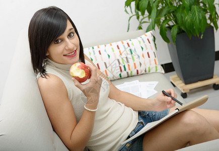 在家里吃苹果的年轻女学生图片
