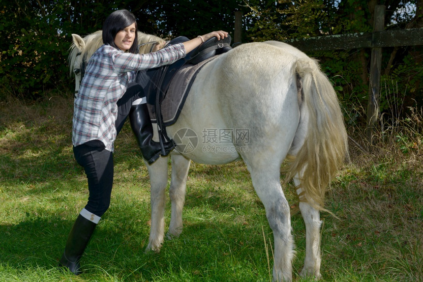 骑白马的年轻美丽黑发女图片