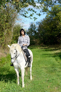 骑白马的年轻美丽黑发女背景图片