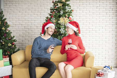 情侣坐在沙发上共饮红酒庆祝圣诞图片