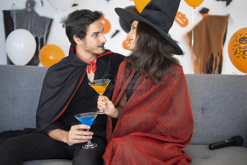 万圣节扮演女巫和吸血鬼干杯的情侣图片