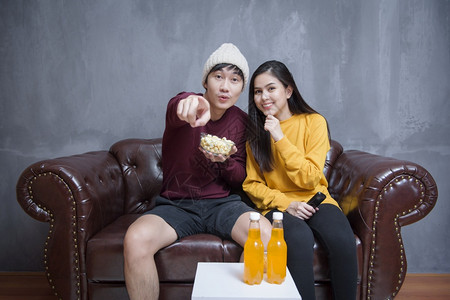 快乐的情侣在家里吃爆米花看电影图片