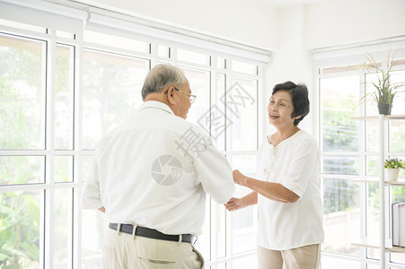快乐的老年亚洲退休夫妇跳舞和享受音乐在家里的客厅享受音乐健康概念图片